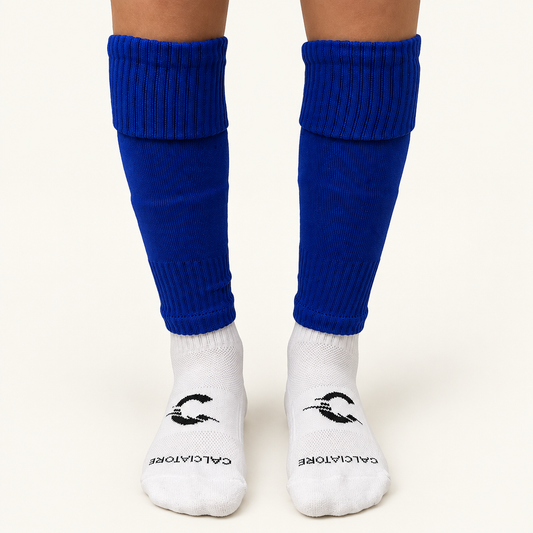 Blue football sock sleeves worn with white socks on a neutral background
